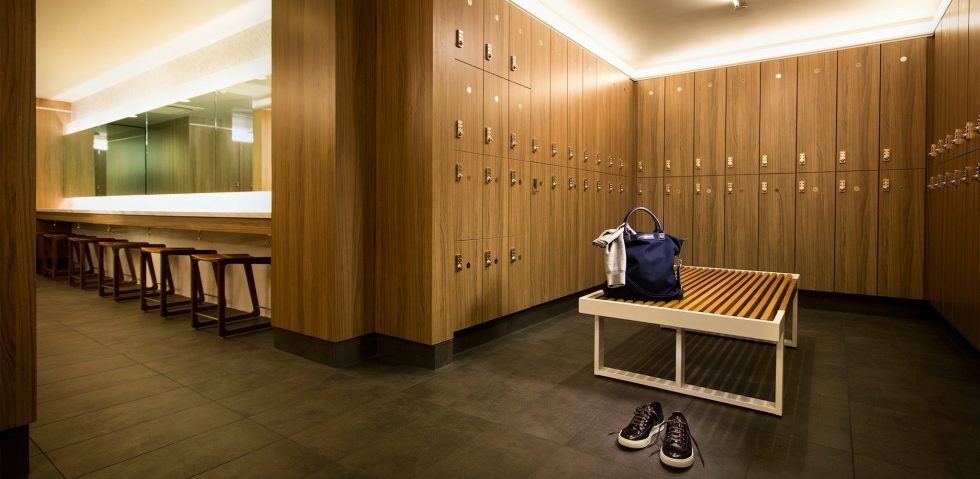 Long grooming station with individual stools and laminate lockers next to it at Equinox Metro Theater.